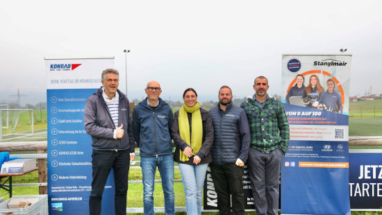 5 Personen, darunter Vertreter von Autohaus Stanglmair und Konrad Autoteile stehen auf einer Wiese vor Werbe-Rollups der beiden Firmen